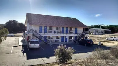 a large building with blue doors and cars parked in a parking lot at Back Country Inn in Boulevard