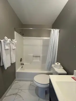 a bathroom with a toilet and a tub and a sink at Back Country Inn in Boulevard