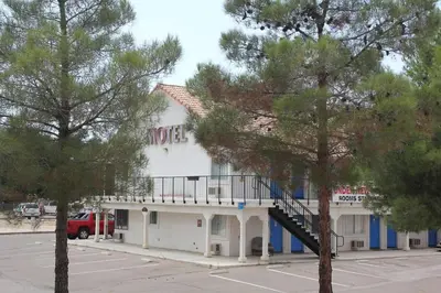 a white building with a balcony on the side of it at Back Country Inn in Boulevard