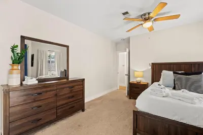 a bedroom with a ceiling fan and a dresser with a mirror at Luxury on Lewis By Cardo - Jacuzzi Fire Pit in San Diego