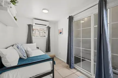 a bedroom with a bed and a glass door at Luxury on Lewis By Cardo - Jacuzzi Fire Pit in San Diego