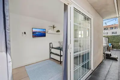 a room with a sliding glass door with a balcony at Luxury on Lewis By Cardo - Jacuzzi Fire Pit in San Diego