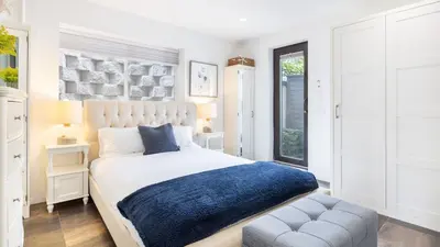 a bedroom with a large bed and a chair at Steps to BeachShops Oceanview Hot TubFirepit Moonlight Modern by AvantStay in Encinitas