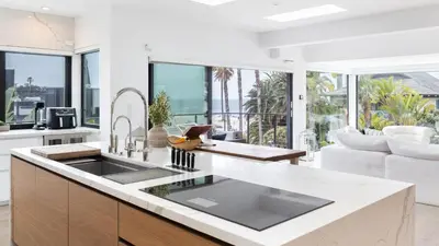 a kitchen with a sink and a living room at Steps to BeachShops Oceanview Hot TubFirepit Moonlight Modern by AvantStay in Encinitas