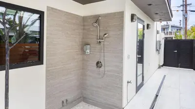 a bathroom with a shower in a wall at Steps to BeachShops Oceanview Hot TubFirepit Moonlight Modern by AvantStay in Encinitas