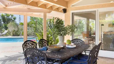 a table with chairs and a vase on a patio at Rancho Real by AvantStay Private Pool Hot Tub Luxe Group Retreat in Rancho Santa Fe