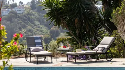 two chairs and a table next to a pool at Rancho Real by AvantStay Private Pool Hot Tub Luxe Group Retreat in Rancho Santa Fe