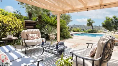 a patio with chairs and a table and a pool at Rancho Real by AvantStay Private Pool Hot Tub Luxe Group Retreat in Rancho Santa Fe