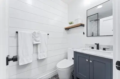 a bathroom with a toilet and a sink and a mirror at Luxury Ground S Oceanfront Unit with Boardwalk Lounge Firepit - AC in San Diego
