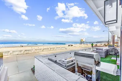 a view of the beach from the balcony of a beach house at Luxury Ground S Oceanfront Unit with Boardwalk Lounge Firepit - AC in San Diego