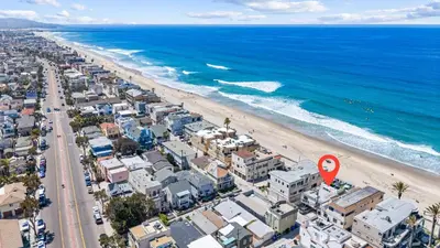 an aerial view of a beach with a red sign at Luxury Ground S Oceanfront Unit with Boardwalk Lounge Firepit - AC in San Diego