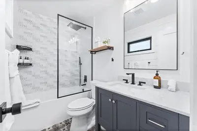 a white bathroom with a toilet and a sink at Luxury Ground S Oceanfront Unit with Boardwalk Lounge Firepit - AC in San Diego