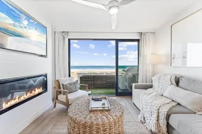 a living room with a couch and a fireplace at Luxury Ground N Oceanfront Unit with Patio Lounge in San Diego
