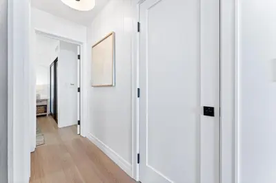 a hallway with white walls and wooden floors at Luxury Ground N Oceanfront Unit with Patio Lounge in San Diego
