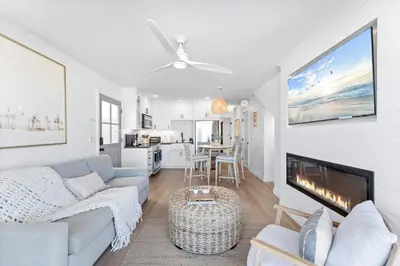 a living room with a couch and a fireplace at Luxury Ground N Oceanfront Unit with Patio Lounge in San Diego