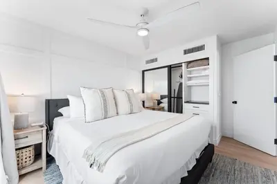 a white bedroom with a large bed and a window at Entire Ground Beachfront Luxury Unit with Patio in San Diego