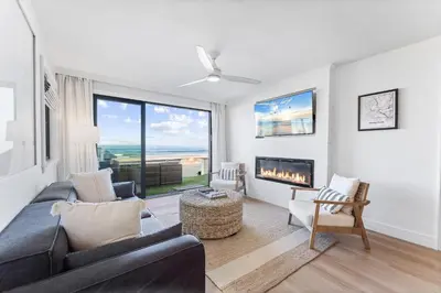 a living room with a couch and a fireplace at Luxury oceanfront fourplex with roof deck sleeps 22 in San Diego