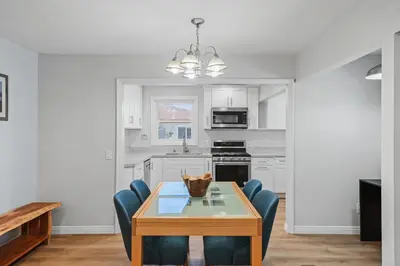 a kitchen with a wooden table and blue chairs at Peaceful Getaway with Renovated Amenities in San Diego