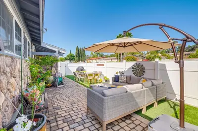 a patio with a couch and an umbrella at Peaceful Poway Vacation Rental Near Shops and Dining in Poway