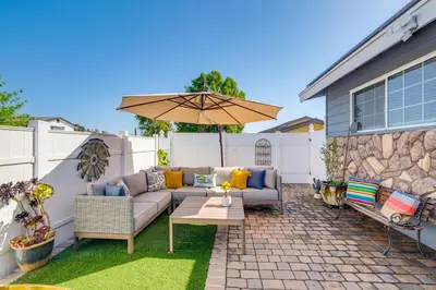 a patio with a couch and an umbrella at Peaceful Poway Vacation Rental Near Shops and Dining in Poway