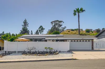 a house with a white fence and a palm tree at Peaceful Poway Vacation Rental Near Shops and Dining in Poway