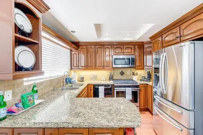 a kitchen with wooden cabinets and stainless steel appliances at Peaceful Poway Vacation Rental Near Shops and Dining in Poway