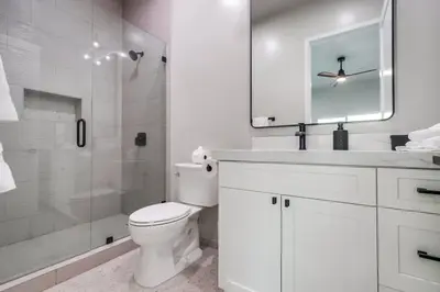 a white bathroom with a toilet and a shower at Serene Resort-Style Escape - Perfect for Families in El Cajon