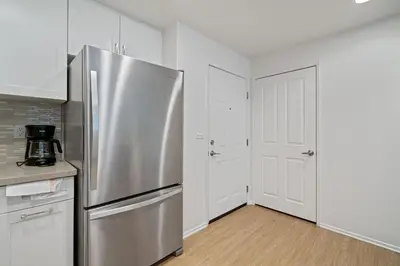 a kitchen with a stainless steel refrigerator and white cabinets at 3 Bedrooms Apt with Pool ,GYM in Irvine