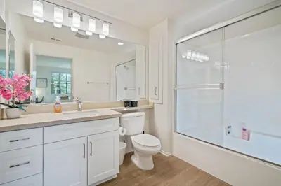 a white bathroom with a toilet and a shower at 3 Bedrooms Apt with Pool ,GYM in Irvine
