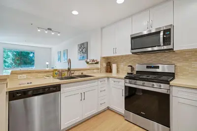 a kitchen with white cabinets and stainless steel appliances at 3 Bedrooms Apt with Pool ,GYM in Irvine