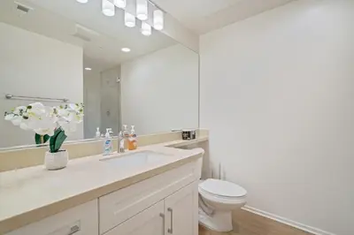 a white bathroom with a toilet and a sink at 3 Bedrooms Apt with Pool ,GYM in Irvine