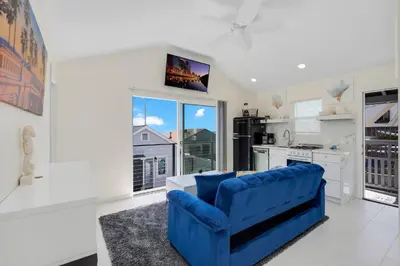 a living room with a blue couch and a kitchen at The Shining Sea B in Oceanside