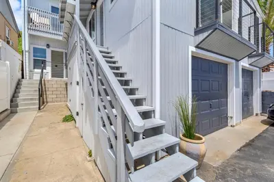 a stairway leading up to a house with a blue door at The Shining Sea B in Oceanside