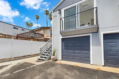 a house with two garage doors and a fence at The Shining Sea B in Oceanside