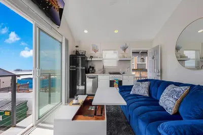 a living room with a blue couch and a kitchen at The Shining Sea B in Oceanside