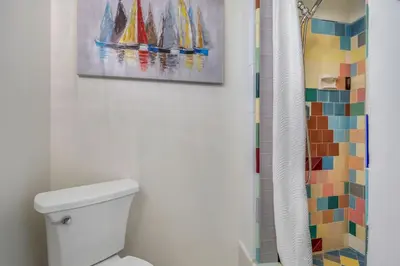 a bathroom with a painting on the wall above a toilet at The Shining Sea B in Oceanside