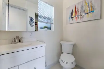 a white bathroom with a toilet and a sink at The Shining Sea B in Oceanside
