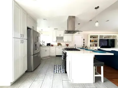 a kitchen with white cabinets and a stove top oven at Family Friendly Retreat with Yard and Play Area, 2000 sq ft, AC, Fiber Optic WiFi in San Diego