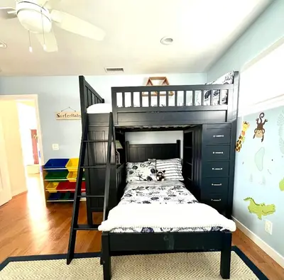 a bedroom with a black bunk bed with a ladder at Family Friendly Retreat with Yard and Play Area, 2000 sq ft, AC, Fiber Optic WiFi in San Diego