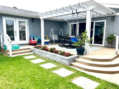 a patio with a table and chairs under a pergola at Family Friendly Retreat with Yard and Play Area, 2000 sq ft, AC, Fiber Optic WiFi in San Diego