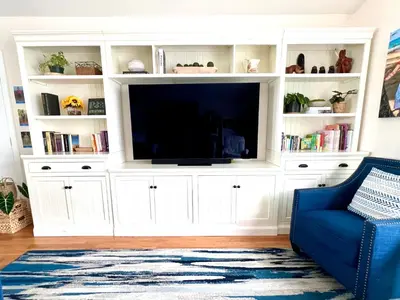 a large white entertainment center with a flat screen tv at Family Friendly Retreat with Yard and Play Area, 2000 sq ft, AC, Fiber Optic WiFi in San Diego