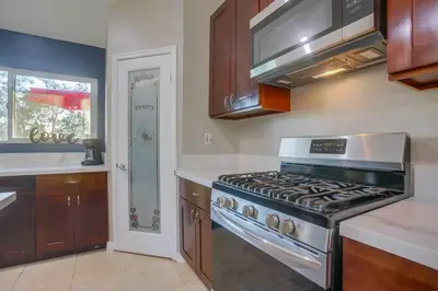 a kitchen with a stove top oven in a kitchen at Large Pool Home on Two Acres with Views! in Vista