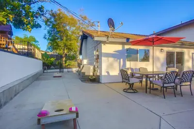 a patio with a table and chairs and an umbrella at Large Pool Home on Two Acres with Views! in Vista
