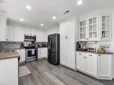 a kitchen with white cabinets and a black refrigerator at Super Spacious Family Vacation House! in San Diego
