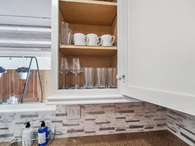 a kitchen cabinet with glasses and wine glasses at Super Spacious Family Vacation House! in San Diego