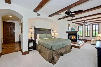 a bedroom with a bed and a fireplace at Heated Pool & Hot Tub Access, Walk 2 Omni Resort, Free Parking, Wi-Fi, Washer & Dryer in Encinitas