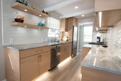 a kitchen with wooden cabinets and stainless steel appliances at La Jolla Windansea Luxury Apt in San Diego