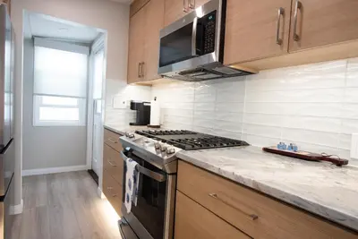 a kitchen with a stove and a microwave at La Jolla Windansea Luxury Apt in San Diego