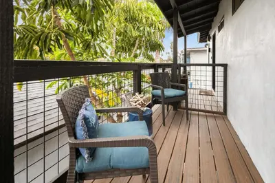 a balcony with wicker chairs on a wooden deck at Modern 1 BR Beach Waves and Sunshine in San Diego