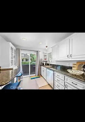a kitchen with white cabinets and a large window at Golden Gateaway in Dana Point